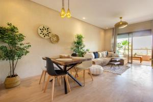 a living room with a table and chairs and a couch at Cocoon in PRESTIGIA GOLF & Wifi - FAMILLE in Marrakesh