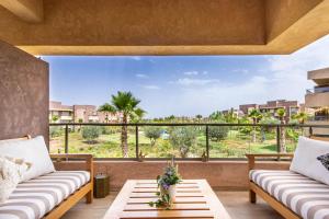 a view from the balcony of a house with two couches at Cocoon in PRESTIGIA GOLF & Wifi - FAMILLE in Marrakesh