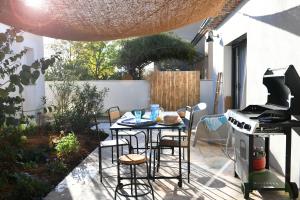 un piccolo patio con tavolo e piano cottura di La maison de Flore a Pernes-les-Fontaines