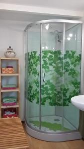 Casa Solara في زاهورا: حمام مع دش مع أوراق مدهونة عليه