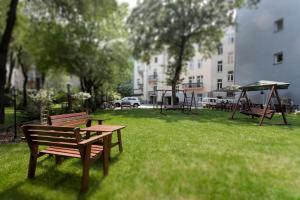 a group of benches in a park with a building at Abella Suites & Apartments by Artery Hotels in Krakow