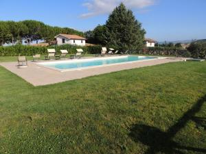 a swimming pool in a yard with chairs around it at Agriturismo Valle Martina in Saturnia +17 photos