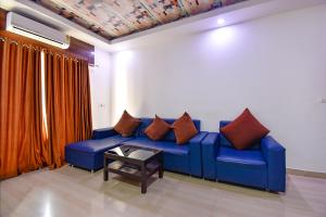 a blue couch with pillows on it in a room at FabHotel Ocean View Apartment, Dabolim in Old Goa