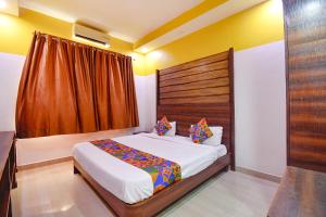 a bedroom with a bed and a large window at FabHotel Ocean View Apartment, Dabolim in Old Goa