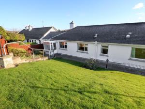 a house with a large lawn in front of it at Lavender Cottage in Castletownbere