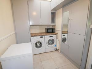 a small laundry room with a washer and dryer at Lavender Cottage in Castletownbere