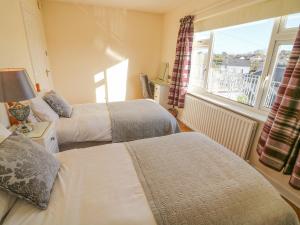 a hotel room with two beds and a window at Lavender Cottage in Castletownbere