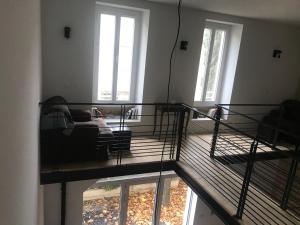 um quarto com uma varanda com uma cama e janelas em L Ostalada em Roquefort-des-Corbières