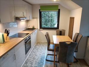 eine Küche mit Tisch und Stühlen und einem Fenster in der Unterkunft Landhaus Dahlem in Hahnenklee-Bockswiese