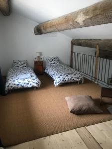 um quarto com 2 camas e um tapete em L Ostalada em Roquefort-des-Corbières