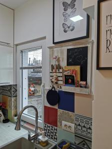 a kitchen with a sink and a wall with colorful tiles at Apartment Jovana Krunska in Belgrade