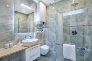 a bathroom with a sink and a shower and a toilet at INSEN Apartamenty Manufaktura Sauna i Masaże Apartament Superior in Łódź