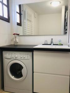 a kitchen with a washing machine and a sink at La petite Normande en ville in Louviers