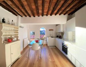 a kitchen with white cabinets and a blue table at CASA ILARIA - Luminoso appartamento con vista nel centro storico in Siena