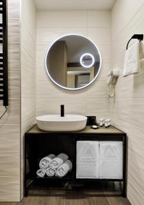 a bathroom with a sink and a mirror at Gudauri Hills Apart Hotel in Gudauri +42 photos