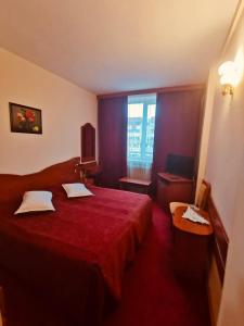 a hotel room with a red bed and a window at HOTEL MUNTENIA in Câmpina