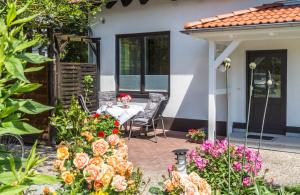 a patio with a table and chairs and flowers at Apartment Romantik Flair in Prerow