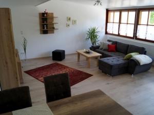 uma sala de estar com um sofá e uma mesa em Ferienwohnung Hegauliebe em Tengen