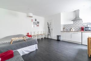 a white room with a bed and a kitchen at Studio indépendant in Bétheny