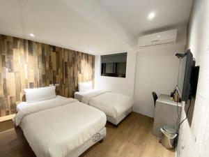 Łóżko lub łóżka w pokoju w obiekcie M Taipei Hotel