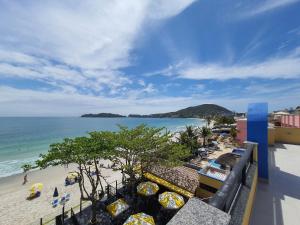 een balkon met uitzicht op het strand van een resort bij Pousada Refugio Costeiro in Bombinhas