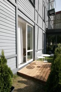 un patio con una mesa y una silla en una terraza en Miško Apartamentai, en Juodkrantė