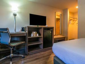 een hotelkamer met een bed, een stoel en een televisie bij Econo Lodge in Cherokee
