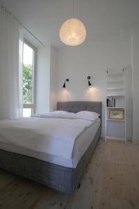 1 dormitorio con cama grande y ventana grande en Miško Apartamentai, en Juodkrantė