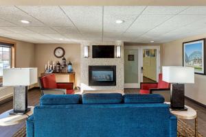 a living room with a blue couch and a fireplace at Comfort Inn & Suites Jackson - West Bend in Jackson
