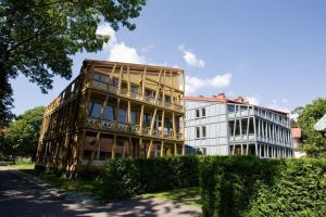a large building next to a white building at Miško Apartamentai in Juodkrantė