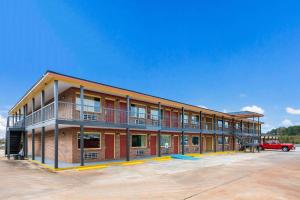 un gran edificio con un camión rojo delante de él en Econo Lodge en Russellville