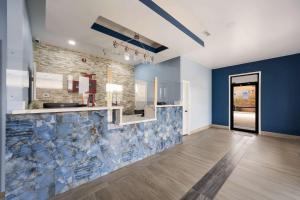 a kitchen with a blue and white tile wall at Econo Lodge Russellville in Russellville