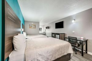 a bedroom with a bed and a desk and a tv at Econo Lodge Russellville in Russellville
