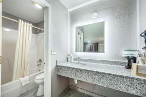 a bathroom with a sink and a toilet and a mirror at Econo Lodge Russellville in Russellville +13 photos