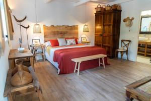 una camera con un grande letto con copriletto rosso di VILLA BINISABEL NOU, CONFORT Y EXCLUSIVIDAD a Sant Lluís