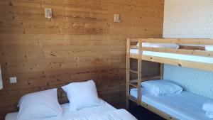 two bunk beds in a room with wooden walls at Plagne centre -Pied de pistes in La Plagne Tarentaise