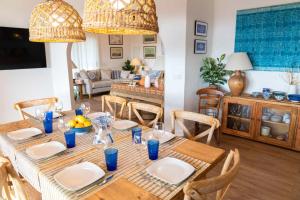 a dining room with a table with chairs and a room with a couch at VILLA BINISABEL NOU, CONFORT Y EXCLUSIVIDAD in Sant Lluis