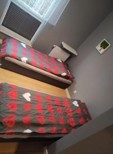 Habitación con 2 camas y colcha de corazones rojos. en Apartament Gdynia Oksywie z Tarasem , darmowy parking, en Gdynia