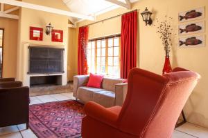 ein Wohnzimmer mit Sofa und Fernseher in der Unterkunft Crimson Cottage in Dullstroom