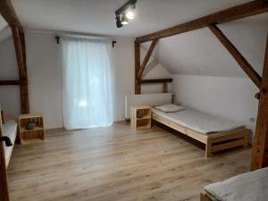 Habitación con cama, suelo de madera y ventana. en Stodoła HOME&CHILL, en Wronki