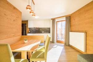 uma cozinha e sala de jantar com uma mesa de madeira e cadeiras em Rosalpina Apt 3 em San Vigilio Di Marebbe
