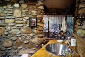 a stone bathroom with a sink and a stone wall at Baviaanskloof Duiwekloof Lodge in Willowmore +68 photos