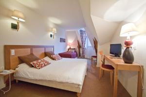1 dormitorio con 1 cama y escritorio con ordenador en Les Ormes Domaine et Resort en Epiniac