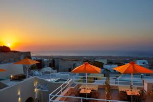 a view of a sunset from a house with umbrellas at Edem Luxury Hotel in Oia