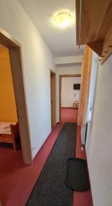 Zimmer mit einem roten Boden und einem Zimmer mit einem Bett in der Unterkunft Hotel Prox in Arnstadt
