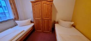 a room with two beds and a wooden cabinet at Hotel Prox in Arnstadt