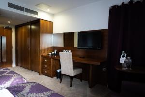 a hotel room with a desk and a television at Ballyrobin Hotel in Aldergrove