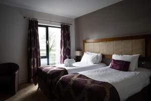 a hotel room with two beds and a window at Ballyrobin Hotel in Aldergrove