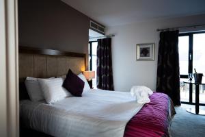 a hotel room with a bed and a window at Ballyrobin Country Lodge in Aldergrove