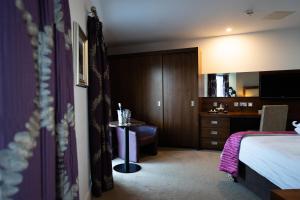 a hotel room with a bed and a desk at Ballyrobin Hotel in Aldergrove